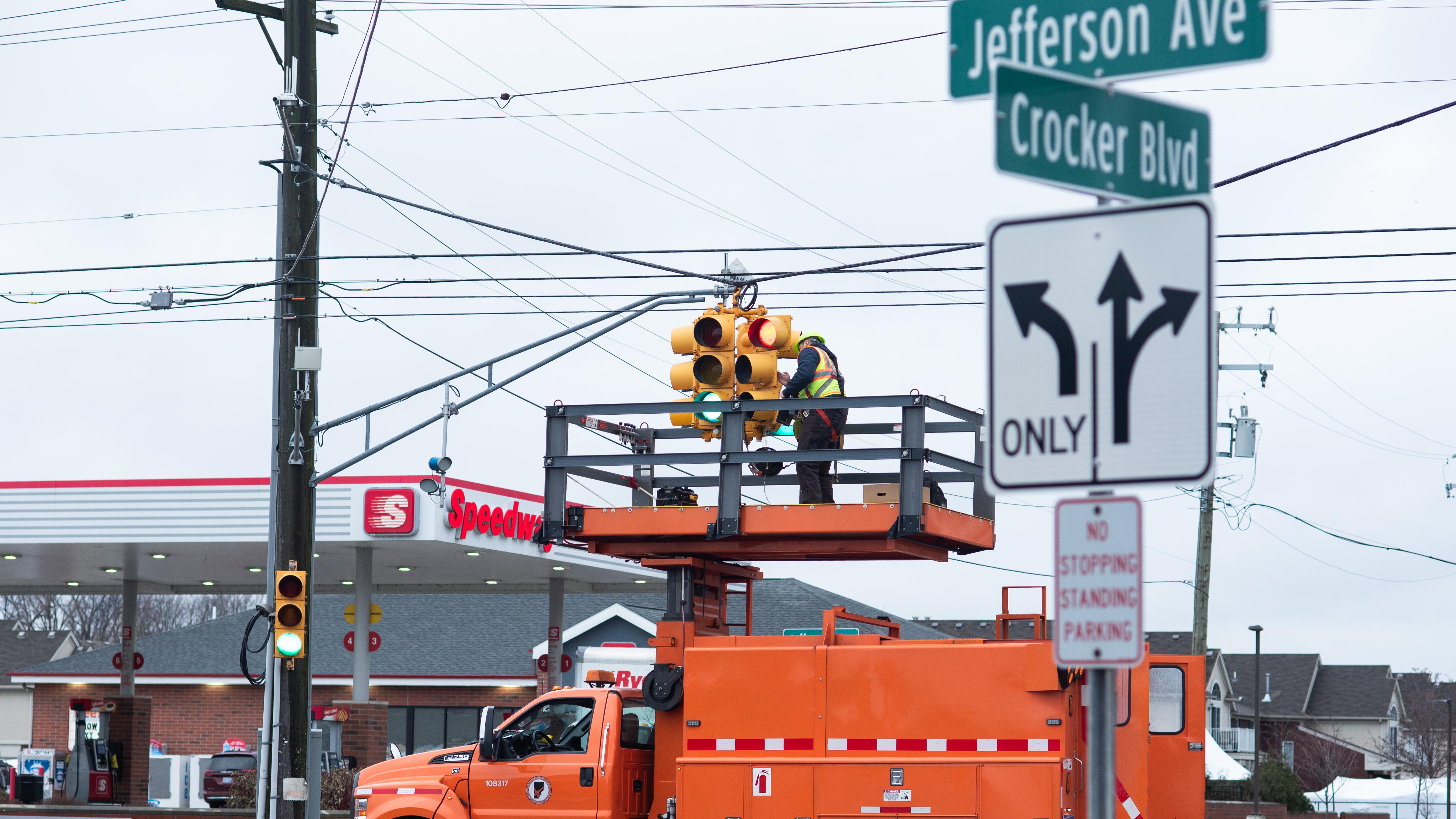 Macomb County Department of Roads personnel install traffic signal heating technology at Crocker Boulevard and Jefferson Avenue