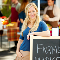 Picture of a Woman Leaning Against a Farmers Market Sign