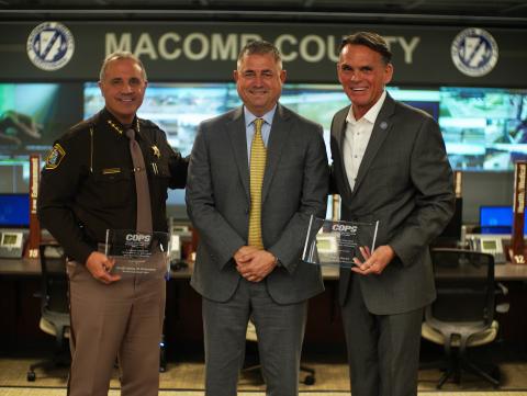 three man stand holding awards