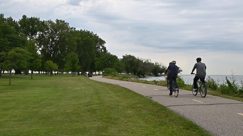a person riding a bike along a lakeshore line