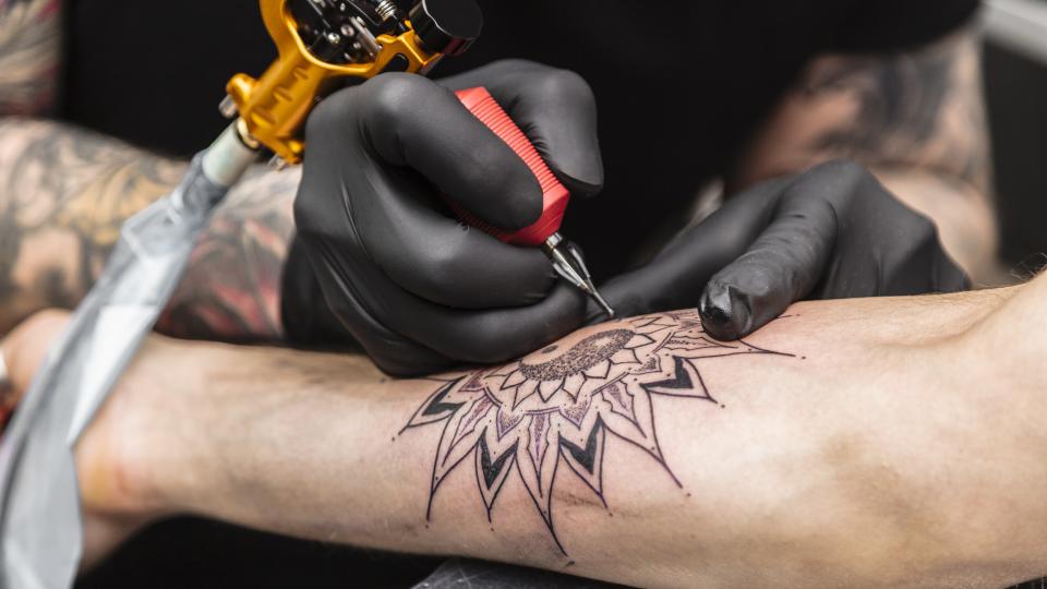 Close up of tattoo being drawn on a person's arm.