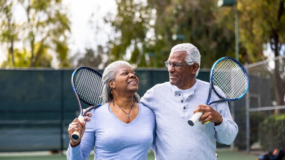two older adults playing tennis