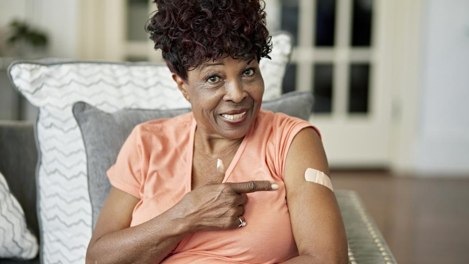 woman displays vaccine bandage