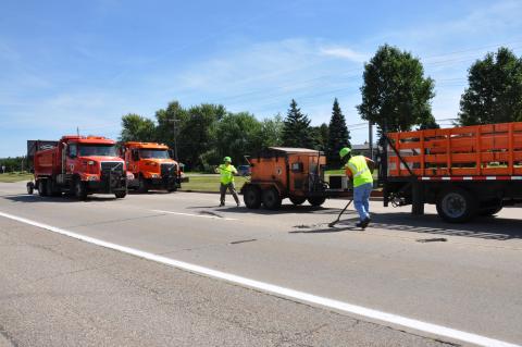 Maintenance team performs patch repair work on a road.
