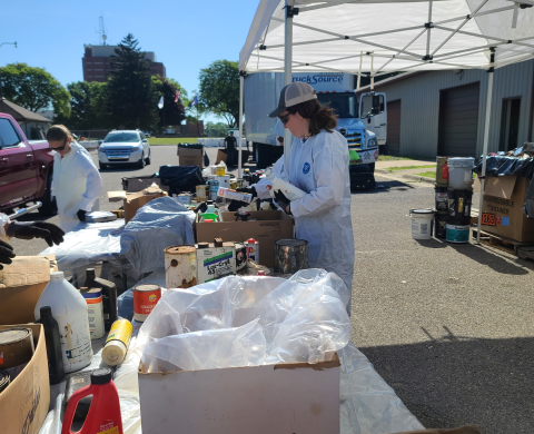 Health Department staff working at a household hazardous waste collection event unloading, sorting, and packing items.