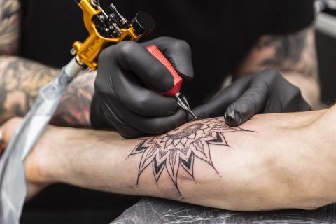 Close up of tattoo being drawn on a person's arm.
