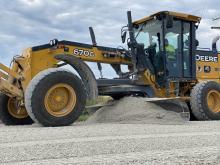 Heavy equipment grading limestone road.