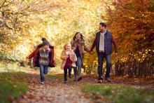 a family walks in the woods during fall