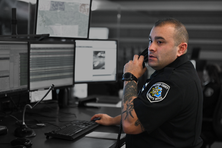 White male dispatcher on phone sitting at computer console
